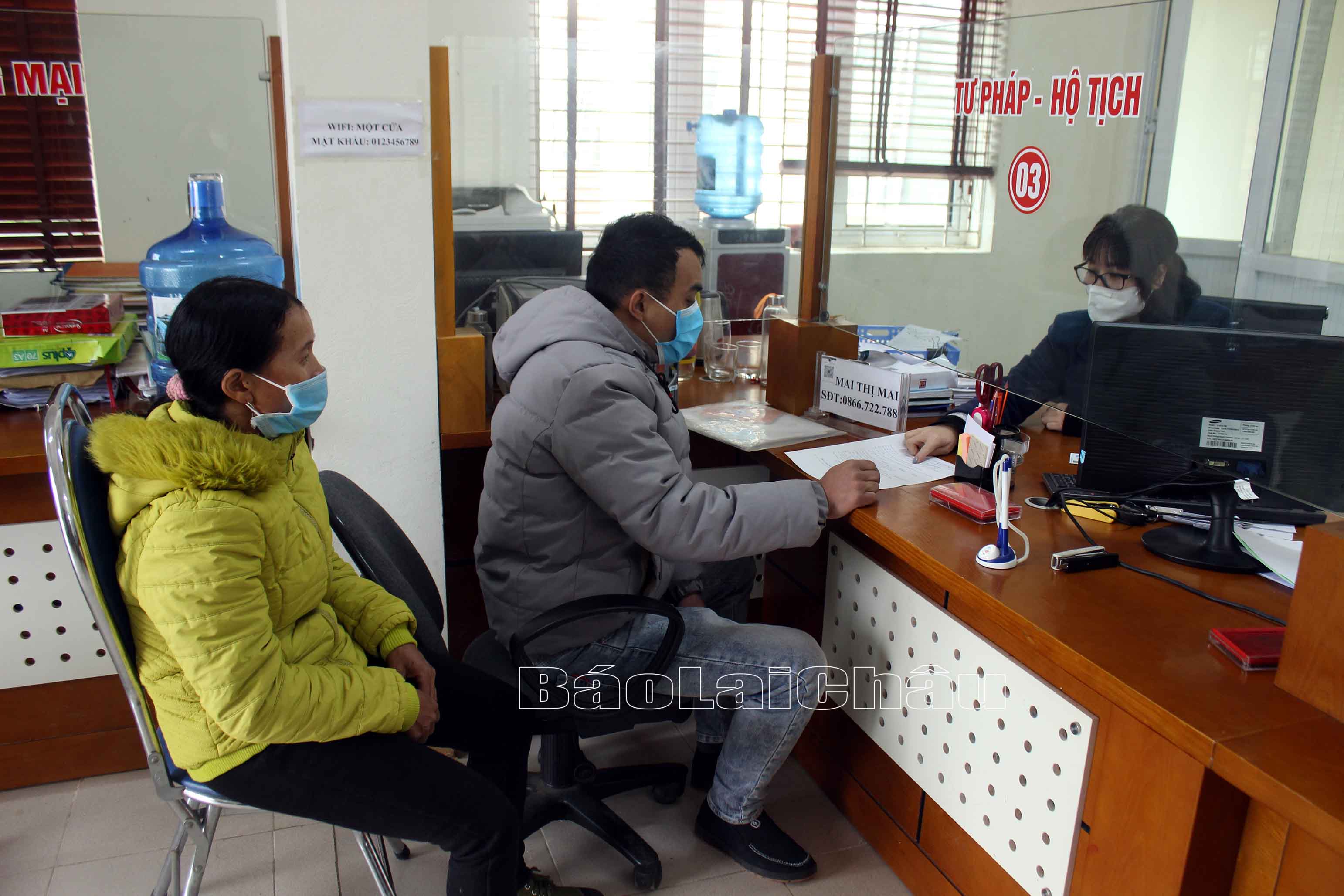 Công chức Bộ phận “Một cửa” UBND huyện Tam Đường hướng dẫn công dân hoàn tất TTHC cấp thẻ bảo hiểm y tế.